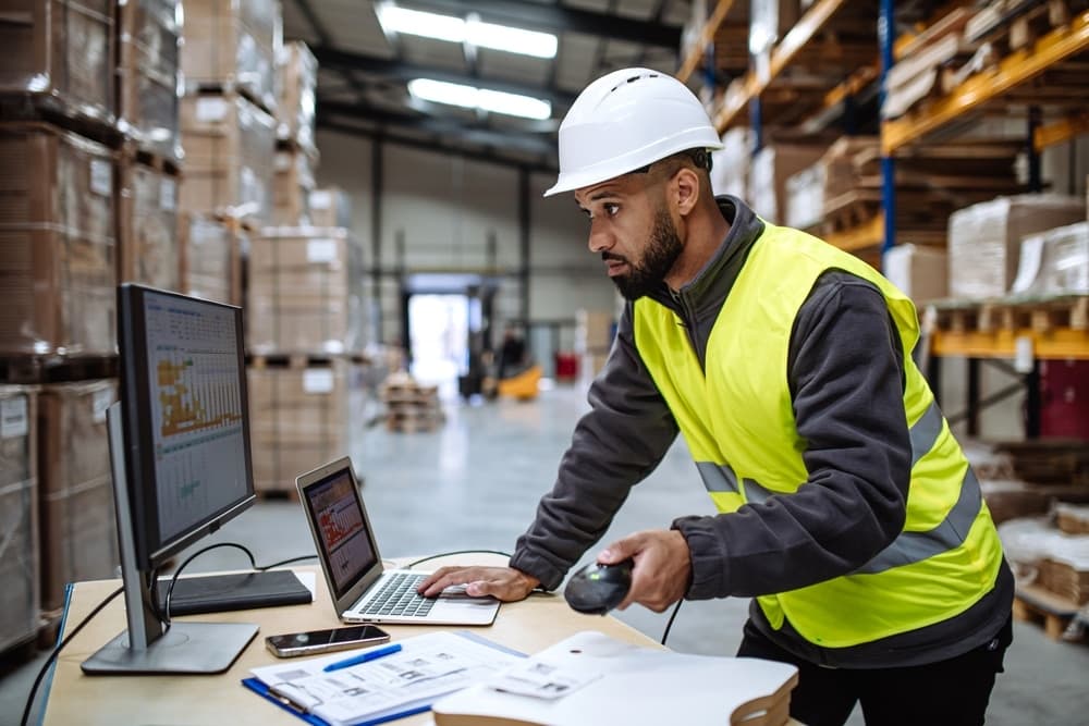 warehouse worker at a desk looking at a computer screen