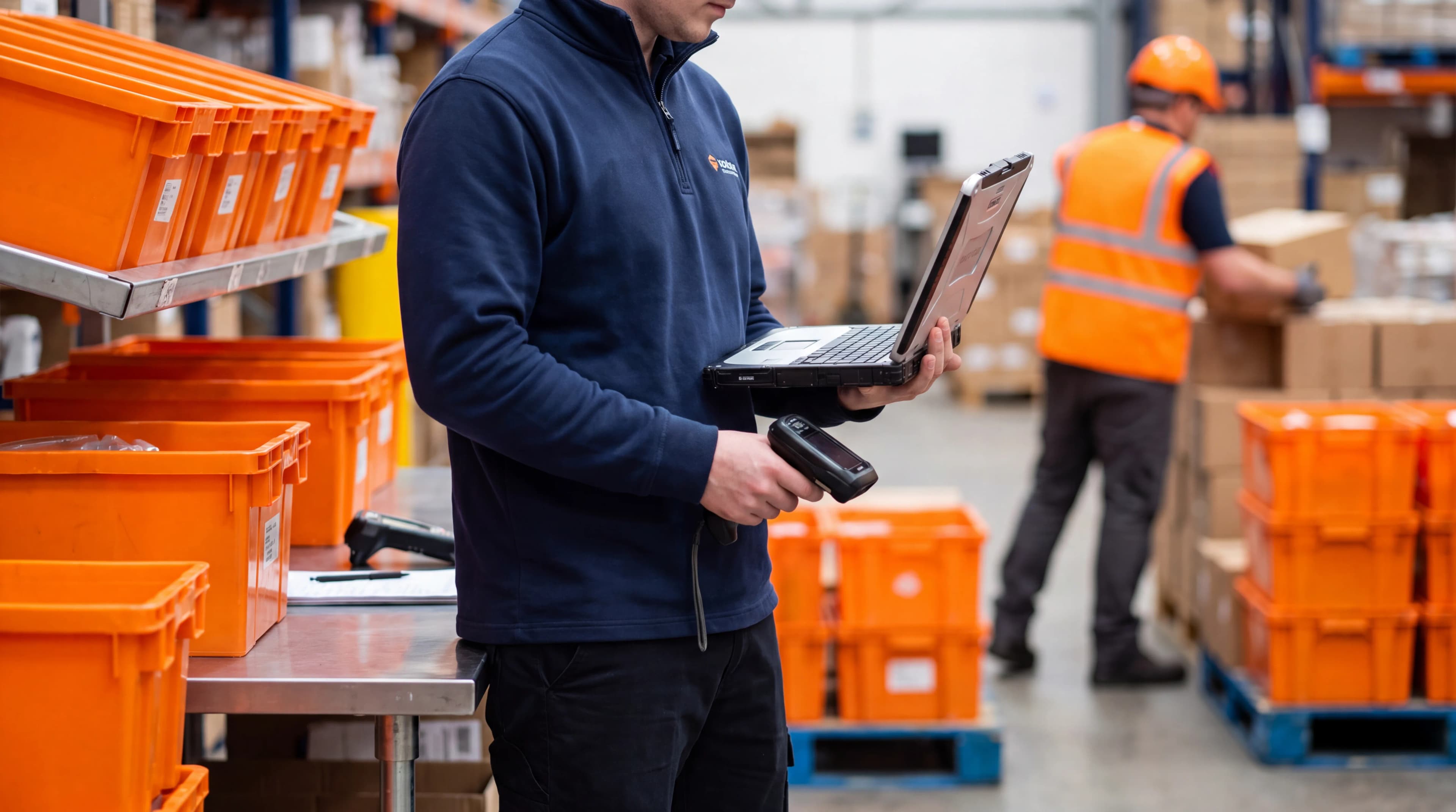 warehouse worker at a desk looking at computer