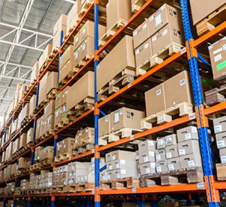 Large warehouse with organized cardboard boxes on orange and blue industrial shelving