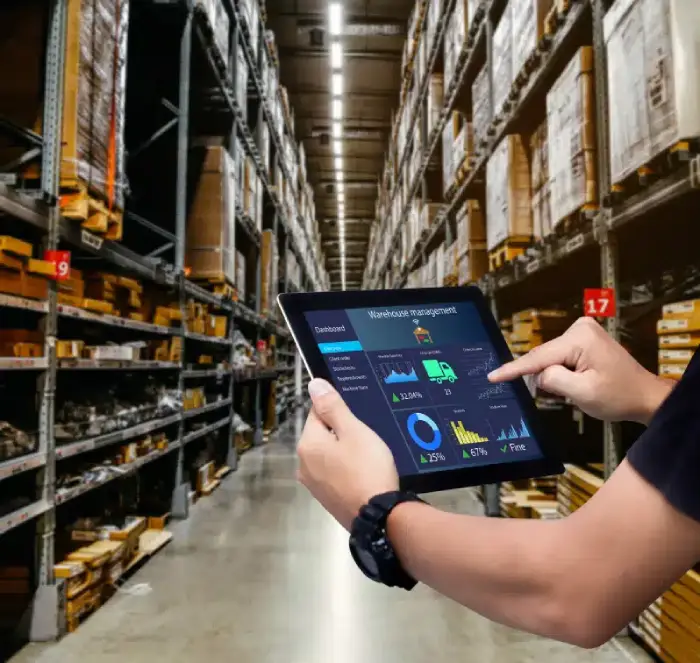 Person using tablet for warehouse management dashboard in industrial storage facility